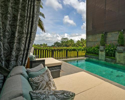 乌布巴厘岛豪华别墅式酒店的后院设有游泳池和沙发