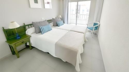 圣地亚哥港罗格斯凯萨蓝海酒店的白色的客房设有两张床和窗户。