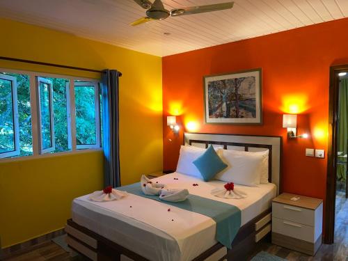 拉迪格岛Chloe's Cottage Self-Catering的一间卧室配有一张橙色墙壁的床