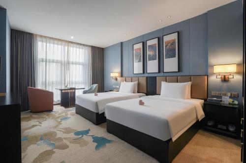 重庆禧满鸿福酒店(重庆江北国际机场店)的酒店客房配有两张床和一张书桌