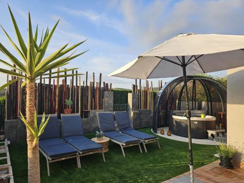 卡拉塔瑞达Sunset sea view & garden Spa Cala Tarida 6p max的庭院配有两把椅子和一把遮阳伞