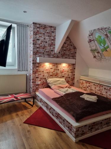 拉登Pension Zum Burgwächter的一间卧室设有一张大床和砖墙