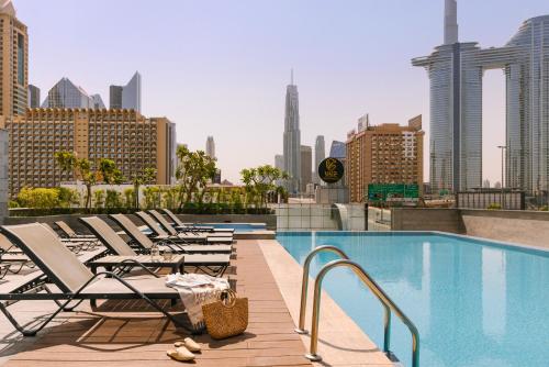迪拜Sonder Downtown Towers的游泳池旁的一排躺椅