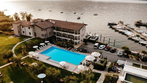 圣费利切德尔贝纳科Bella Hotel & Restaurant with private dock for mooring boats的享有带游泳池和码头的房屋的空中景致