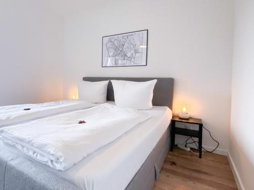 诺伊斯Schöne Wohnung mit Rheinblick/Düsseldorf/Neuss/Messe的一间卧室配有一张白色大床和床头柜