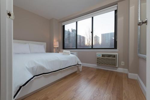 纽约Awesome 2 Bedroom Apartment in NYC的一间卧室设有一张床和一个大窗户