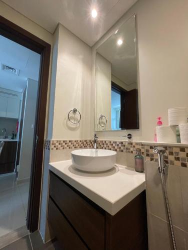 迪拜Wonderful Reva Aparthotel Downtown的一间带水槽和大镜子的浴室