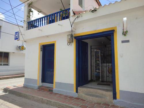里奥阿查Casa Flor Hostel & Drinks的街上有蓝色和黄色的门的建筑