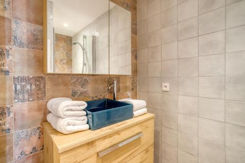 勒拉旺杜Roc Hotel - Hôtel 4 étoiles les pieds dans l'eau的一间带水槽和台面毛巾的浴室