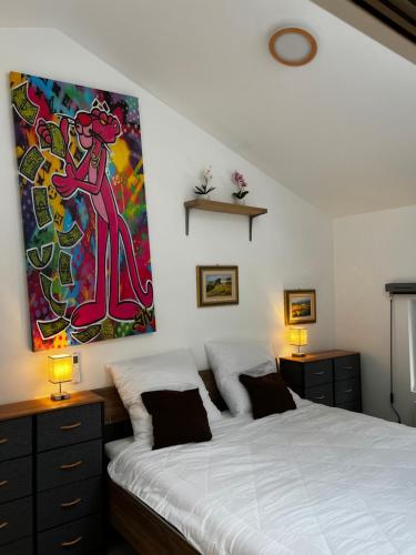 迪尔巴克Laicas lodge的卧室配有一张床,墙上挂有绘画作品