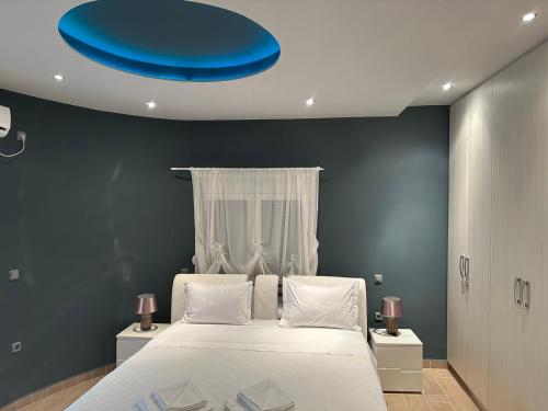马尔马里Villa Marmari 1的一间卧室设有一张蓝色天花板的大床