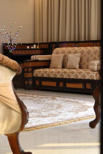 استراحة الغيل صحار的一间带两张床和一张沙发的客厅