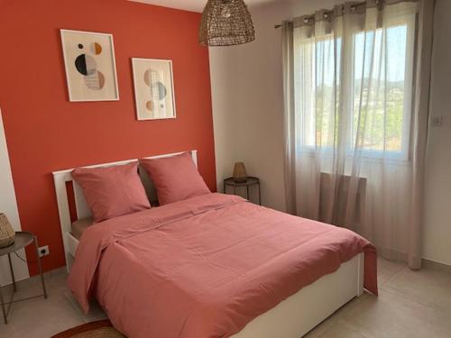 瓦隆蓬达克vacances en Ardéche "maison Chauvet"的一间卧室设有一张红色墙壁和窗户的床
