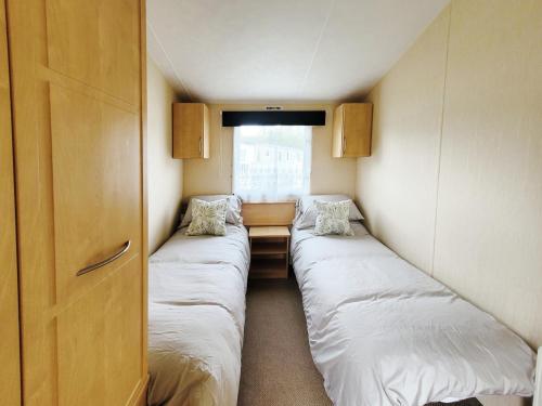 南塞尔尼Kingfisher Corner的小房间设有两张床和窗户