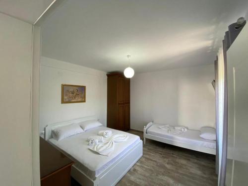 伏罗拉Arlind's Apartaments的白色的客房设有两张床和浴缸。