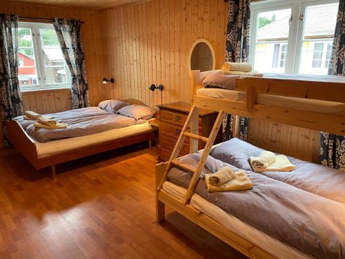 勒罗斯Kjerkgata 6 - midt i Røros sentrum的客房设有三张双层床和一扇窗户。