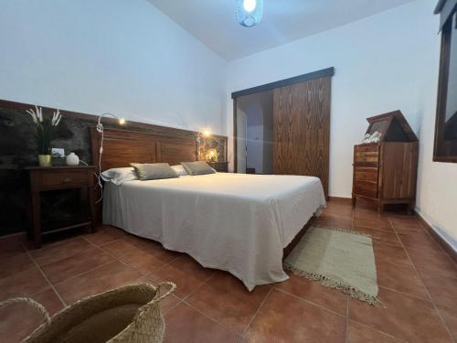加拉奇科CASA CANARIA ACERÓ的卧室配有一张白色大床和一把椅子