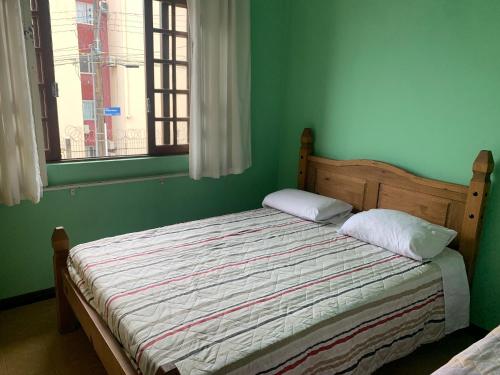 弗洛里亚诺波利斯Ap Família no Estreito的绿色卧室内的一张床位,设有窗户