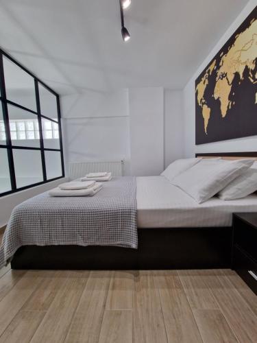 塞萨洛尼基SKG City Loft的卧室配有一张大床,墙上挂有地图