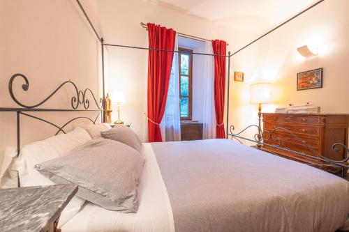 RustigazzoVeleia Romana B&B的一间卧室配有大床和红色窗帘