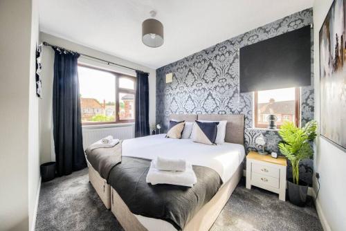 考文垂LOW RATE - Coventry for 3 BedRoom House with Garden, FREE Netflix and Unlimited Wi-fi - Driveway Parking - AGC的一间卧室设有一张大床和一个窗户。