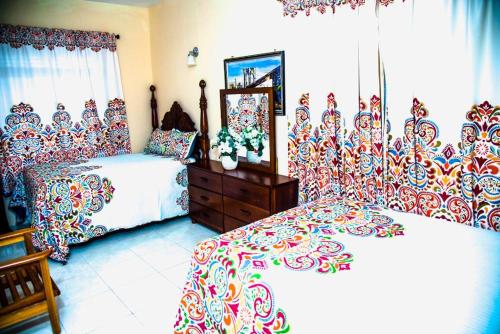 尼格瑞尔Dela de-Rose Guest House Negril Jamaica的一间卧室配有两张床和镜子