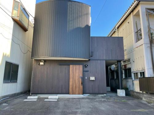 沼津Guest House Numazu Port - Vacation STAY 70099v的停车场内有木门的建筑