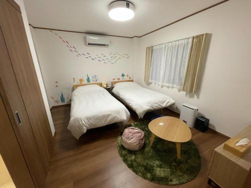 沼津Guest House Numazu Port - Vacation STAY 70099v的小房间设有两张床和一张桌子