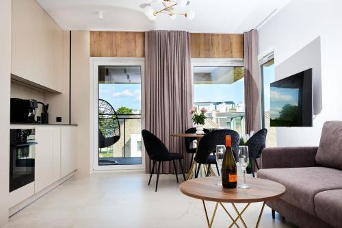 吉日茨科Apartament E18 w Nautica Resort nad jeziorem w Giżycku的客厅配有沙发和一张桌子及一瓶葡萄酒