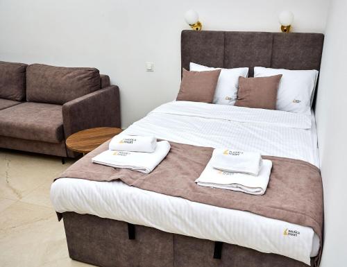 吉日茨科Apartament E18 w Nautica Resort nad jeziorem w Giżycku的一张大床,在沙发旁配有两条毛巾