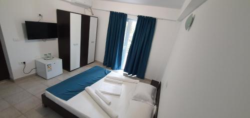 科斯蒂内什蒂Vila Bella 2M的卧室配有白色的床和蓝色窗帘