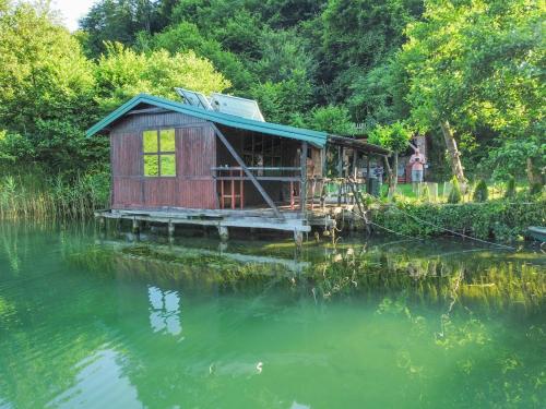 亚伊采ECO cabin Plivsko jezero Jajce的水中反射的河上房子