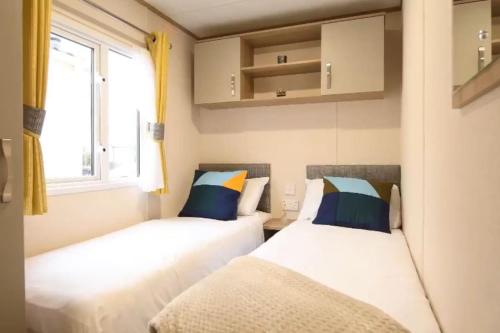 East MerseaRohannah static Caravan Fantastic Family and Friends Holiday的小型客房 - 带2张床和窗户