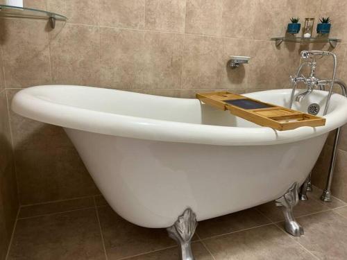 乔治敦The Diver's Inn Grand Cayman的白色浴缸,上面有木制托盘