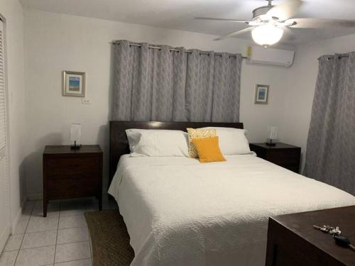 乔治敦The Diver's Inn Grand Cayman的卧室配有一张白色大床和黄色枕头