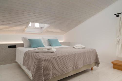 安德罗斯ISTION ANDROS LUXURY SUITES的白色卧室配有一张带蓝色枕头的大床