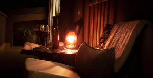 锡萨克Apartment Sladic的一张桌子,上面放着蜡烛和两杯葡萄酒
