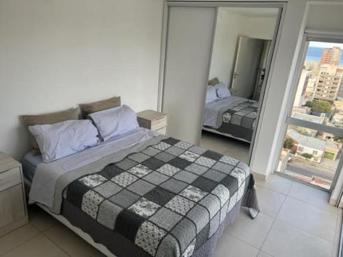 里瓦达维亚海军准将城Moderno depto con vista panorámica的一间卧室设有一张床和一个大窗户