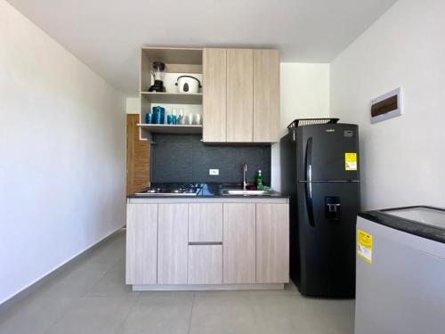 圣贝尔纳多德尔比恩托NAHIR apartamento de playa en condominio Palmar del viento的厨房配有黑色冰箱和炉灶。
