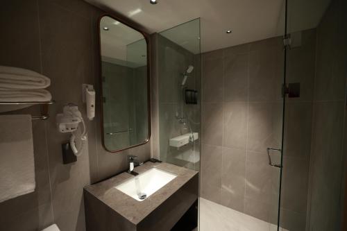 仁川市仁川机场1号航站楼过境酒店的浴室配有盥洗盆和带镜子的淋浴