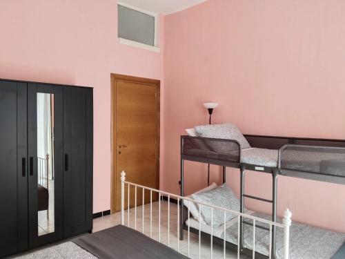 巴里Casa Vacanze Arturo的粉红色墙壁的客房内设有两张双层床。