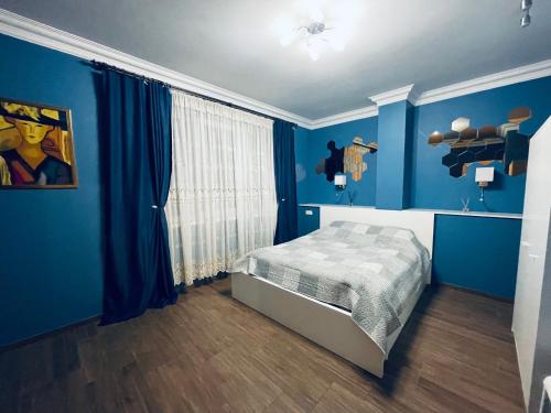 克莱佩达Rooms4Rent Cottage的一间拥有蓝色墙壁的卧室,其中配有一张床