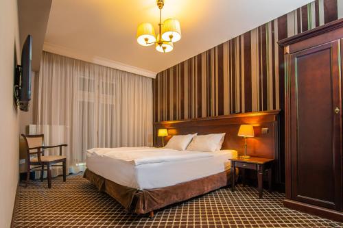 奥尔什丁韦林斯基酒店的卧室配有1张床、1张桌子和1把椅子
