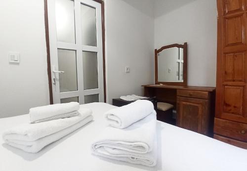 费特希耶Daidala Life的浴室在床上配有白色毛巾和镜子