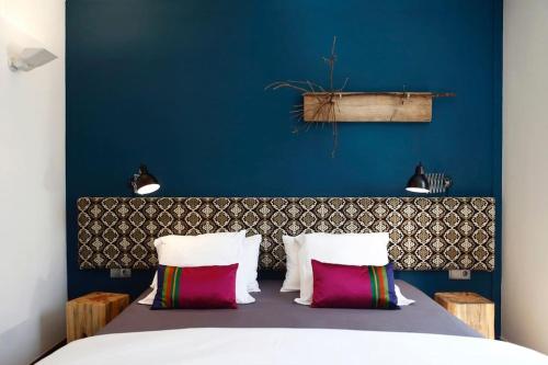 巴塞罗那Apartment Vila Olímpica Barcelona next to beach & garden的一间卧室设有蓝色的墙壁和一张带枕头的床。