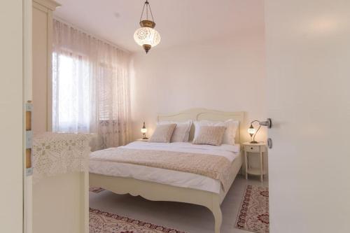 维索科Apartment ADA的白色的卧室设有白色的床和窗户。
