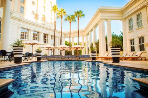 开普敦库里南街南方阳光酒店的棕榈树建筑前的游泳池