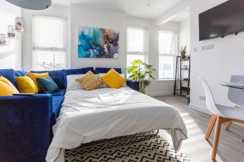 滨海绍森德2 bed apartment near the beach的客厅里配有带黄色枕头的蓝色沙发