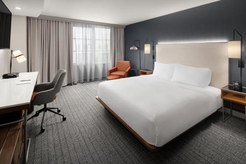 贝尔维尤西雅图贝尔维尤/市中心万怡酒店的酒店客房设有一张白色大床和一张书桌