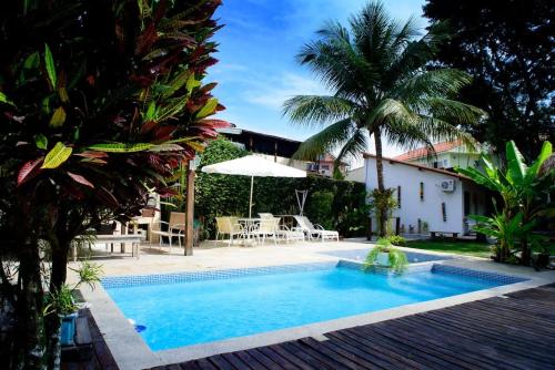 尼泰罗伊Casa Bali 1 2 3的一座游泳池,位于带房子的庭院中间